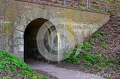 Narrow lane leading to an arched tunnel entrance Stock Photo
