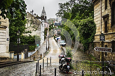 Narrow little street on Monmartre, Paris, France, leading to the Sacred Heart basilica Editorial Stock Photo