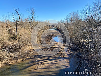 Narrow muddy road surrounded by deciduous trees in Fredericksburg, Virginia Stock Photo