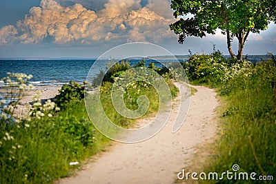 A narrow path leads to the beach from the sea Stock Photo