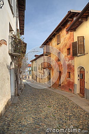 Narrow paved street among houses in Saluzzo. Stock Photo