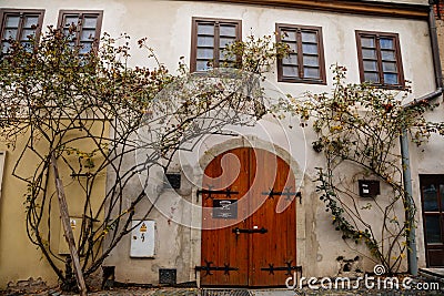 Narrow picturesque street with colorful buildings in old historic center, vintage oval wooden doors with wrought iron hinges and Editorial Stock Photo