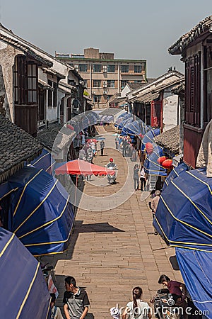 Narrow shopping street with blue awnings in Tongli, China Editorial Stock Photo