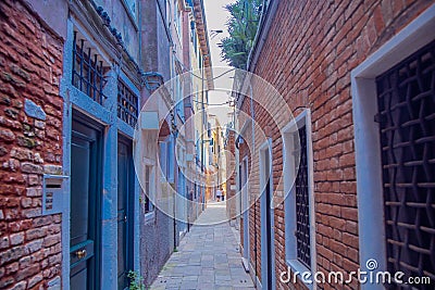 A narrow street with brick houses and Windows with bars Stock Photo