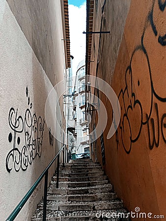 Narrow street between houses in europe. Graffiti on the wall. Stock Photo