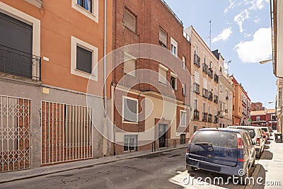 Narrow street with low buildings with clay brick facades with balconies Stock Photo