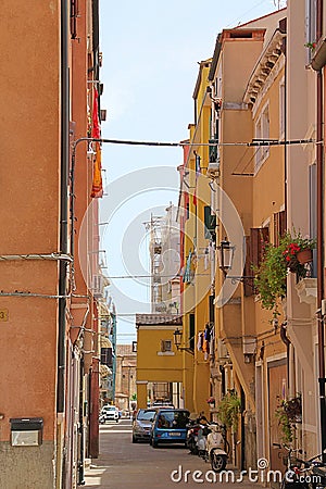 narrow street, small street in an Italian city, parked cars in a narrow passage between houses Editorial Stock Photo