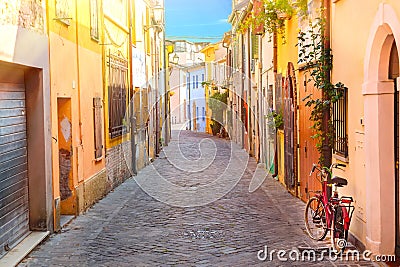 Narrow street of the village of fishermen San Guiliano with colorful houses and a bicycle in early morning in Rimini, Italy Stock Photo