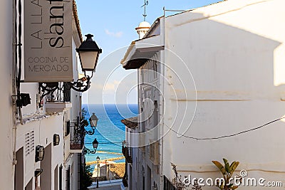 Narrow street of white houses with forged lanterns overlooking the sea in the old town of Altea, Spain on a hot sunny Editorial Stock Photo