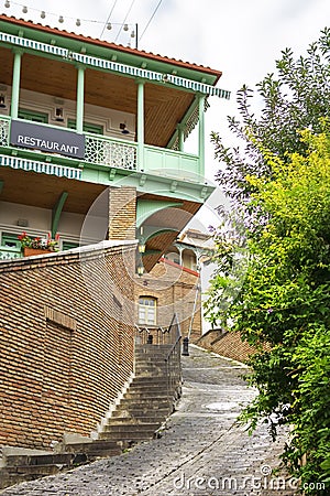 Narrow streets of Tbilisi old town with beautiful colorful wooden balconies and red brick houses Editorial Stock Photo