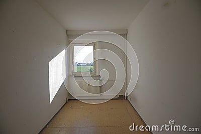 Narrow unrenovated room with heater and window, concept for housing shortage and small space living copy space Stock Photo