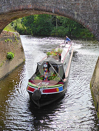 Canal narrowboat passing under bridge Editorial Stock Photo