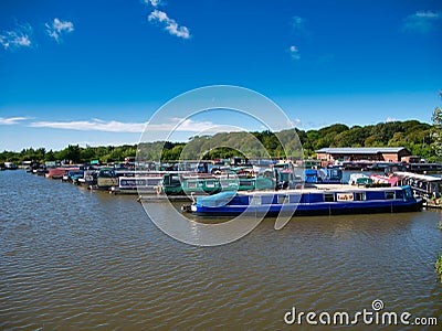 Narrowboats moored at pontoons at Scarisbrick Marina on the Leeds Liverpool Canal in Lancashire in the UK Editorial Stock Photo