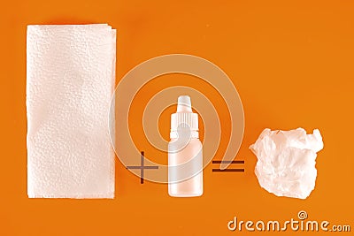 Nasal spray and used paper handkerchiefs on an orange background with a copy of the space. The concept of treating a cold or Stock Photo