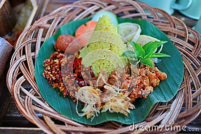 Nasi Kuning. Javanese turmeric rice with assorted side dishes Stock Photo