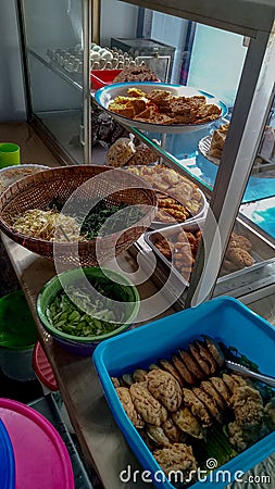 Pecel rice,one of the traditional Indonesian foods consisting of boiled spinach, spicy peanut sauce, fried tofu,and fried tempeh. Stock Photo