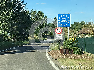 National border roadsign entering Federal Republic of Germany, with stars on blue as symbols for European Union member Stock Photo