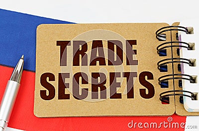 On the flag of Russia lies a pen and a notepad with the inscription - TRADE SECRETS Stock Photo