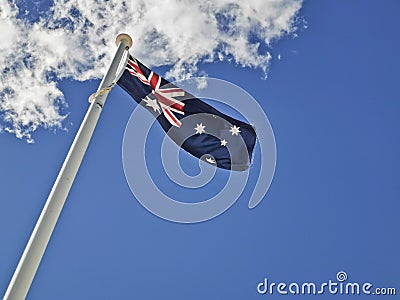 National flag of Australia consists of Union Jack and Southern Cross stars constellation in blue sky sunny day with white cloud Stock Photo