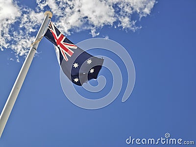 National flag of Australia consists of Union Jack and Southern Cross stars constellation in blue sky sunny day with white cloud Stock Photo