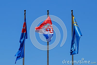 National flag of Croatia and region of Dalmatia on poles in Makarska, Croatia on June 21, 2019. Editorial Stock Photo