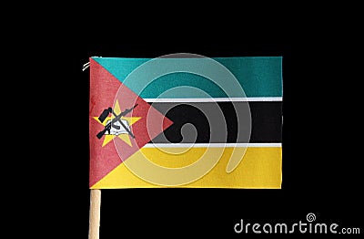 A national flag of Mozambique on toothpick on black background. Consists of horizontal tricolour of green, white edged black and y Stock Photo