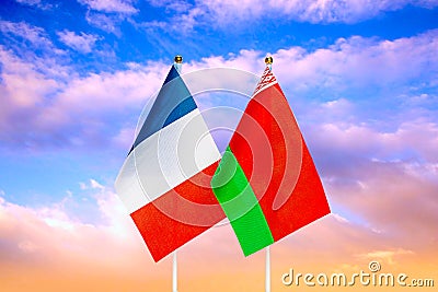 National flags of France and Belarus against the sky at sunset. Stock Photo