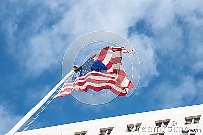 National pride. The US flag against the background of the blue sky and the City Hall Los Angeles Stock Photo