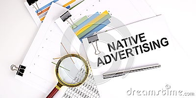 Native Advertising text on the white paper on light background with charts paper Stock Photo