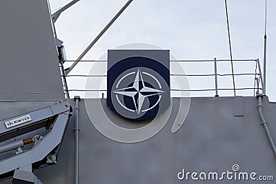 NATO Joint Military Symbology, a dark blue field charged with a white compass rose emblem, with four white lines radiating from Editorial Stock Photo