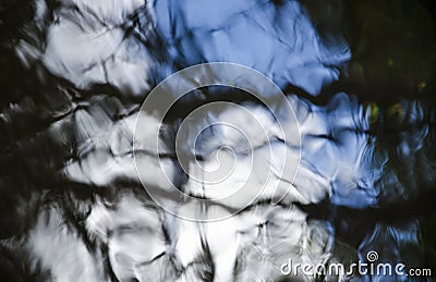 Natural abstraction: water in motion that reflects the white and blue sky Stock Photo