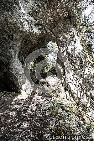 Natural arch bellow Poludnica hill in Nizke Tatry mountains in Slovakia with trees on the background Stock Photo