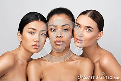 Three Pretty Girls Posing Shirtless On Gray Studio Background Stock Photo