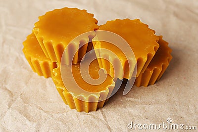 Natural beeswax cake blocks on parchment paper, closeup Stock Photo