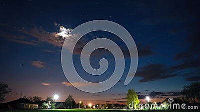 Natural Bold Bright Blue Sky Background. Night Starry Sky With Glowing Stars Above Countryside Landscape. Time Lapse Stock Photo