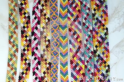 Natural bracelets of friendship, colorful woven friendship bracelets, snow background, rainbow colors, checkered pattern Stock Photo