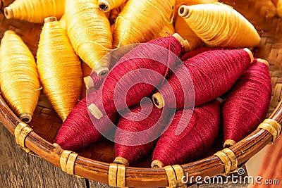 Natural colour of red and yellow cotton spools of thread use for weaving textile with tradition loom Stock Photo