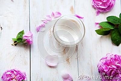 Natural cosmetic cream skincare product wellness and relaxation surrounded by rose blossom on white wooden table Stock Photo