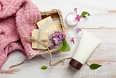 Natural cosmetics with lilac flowers. Set of cream and towel rolls. Stock Photo