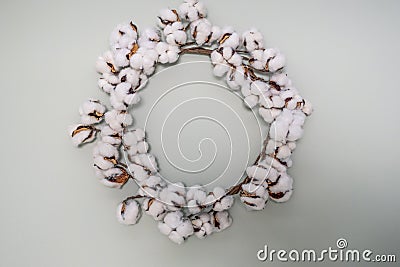 Natural cotton wreath on light aqua wall Stock Photo