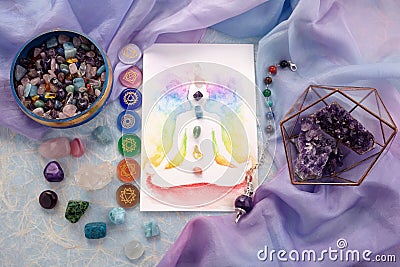 Natural crystals and pendulum on pastel silk background. Reiki background with card. Stock Photo