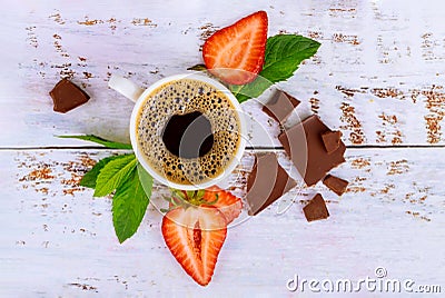 Natural dark coffee with strawberry and chocolate on white wooden table Stock Photo