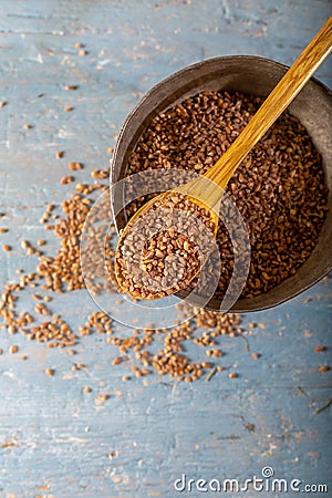 Natural Einkorn bulgur in wooden spoon on wooden background. Top view. Siyez. Stock Photo