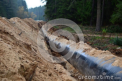 Natural gas pipeline construction work. A dug trench in the ground for the installation and installation of industrial gas and oil Stock Photo