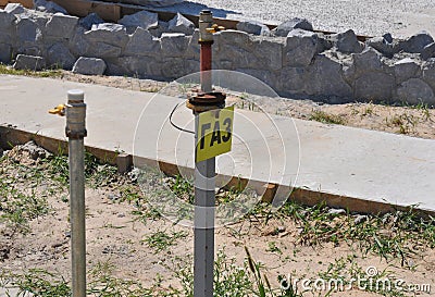 Natural gas pipeline outlet from the ground with a sign gas in cyrillic alphabet. Metal natural gas pipe outlet, post near the Stock Photo