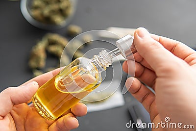 Natural herb, close up, medical marijuana concept, CBD cannabis OIL. hemp product, Hand holding bottle Stock Photo