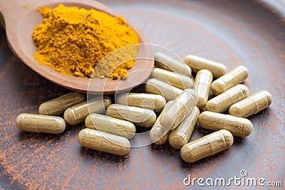 Natural herb food supplement turmeric veggie capsules and spoon Stock Photo