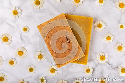 Natural homemade soap with chamomile flowers on a wooden table. Stock Photo