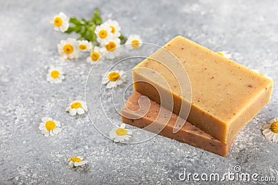 Natural homemade soap with chamomile flowers on a wooden table. Stock Photo