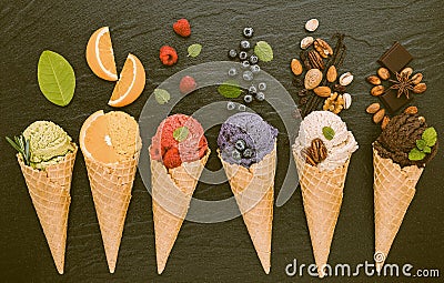 Icecreams with fruit and nut ingredients - ice cream cones on a black background Stock Photo